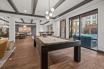 A billiard table is in the middle of a room with wood flooring at 1010 Dilworth Apartments, Charlotte, NC, 28204